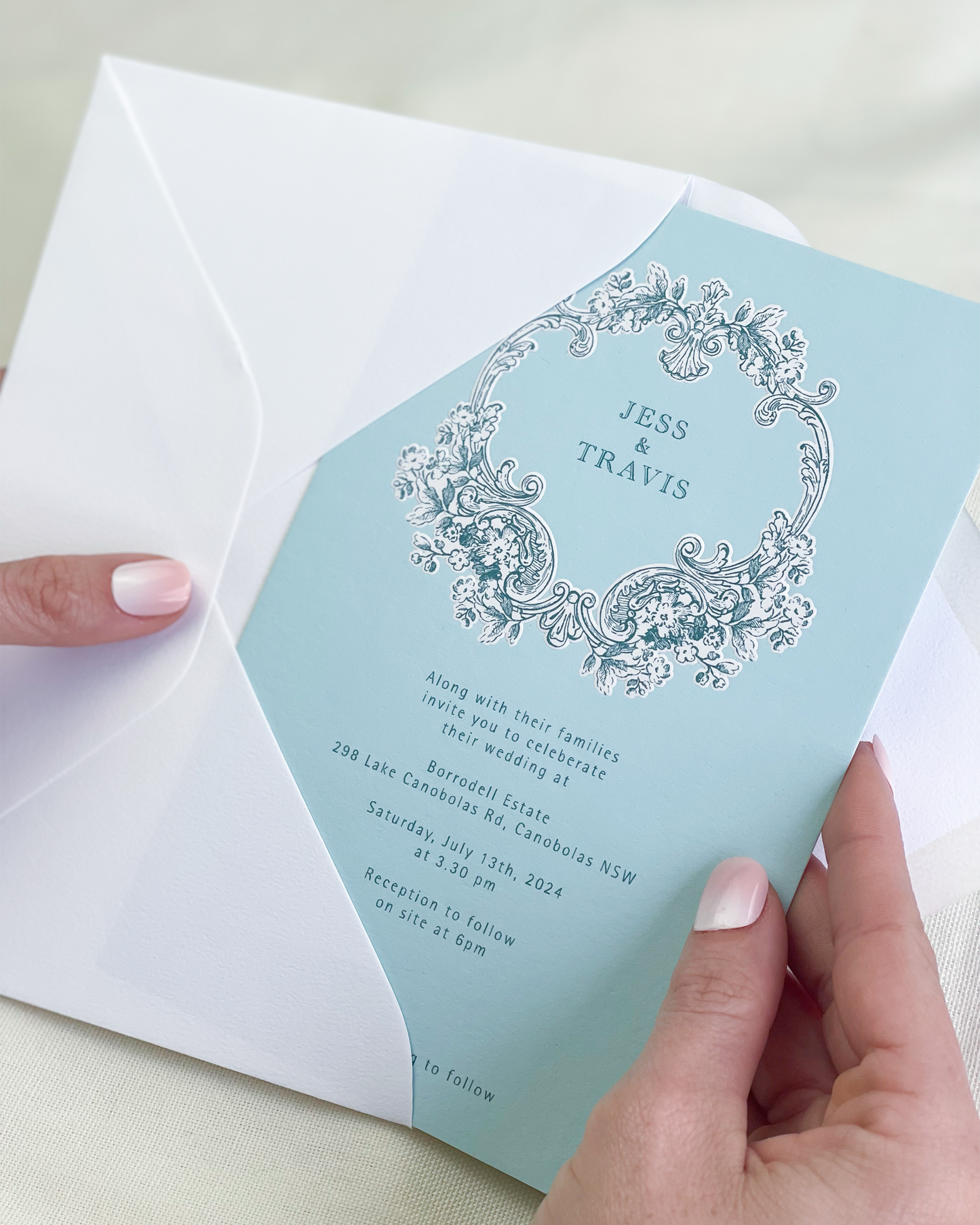 Travis light blue wedding invitation with decorative elements including embossed motif. Designed by Communique Design.