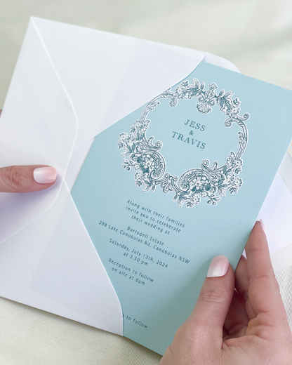 Travis light blue wedding invitation with decorative elements including embossed motif. Designed by Communique Design.