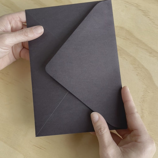 The Avalon wedding invitation video show its rich black heavy card stock, couples names in gold foil and other details in white digital ink. Designed by Communique Design.