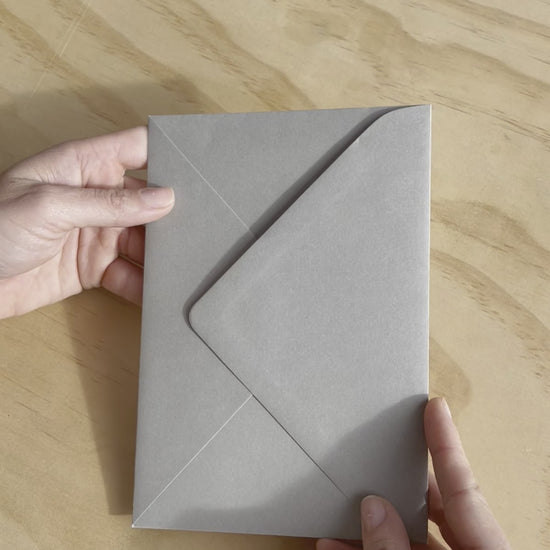 The Brooklyn wedding invitation with embossed couples names on white heavy card stock. Also featuring a grey enveloping. Designed by Communique Design.