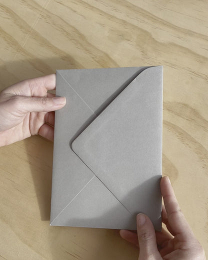 The Brooklyn wedding invitation with embossed couples names on white heavy card stock. Also featuring a grey enveloping. Designed by Communique Design.