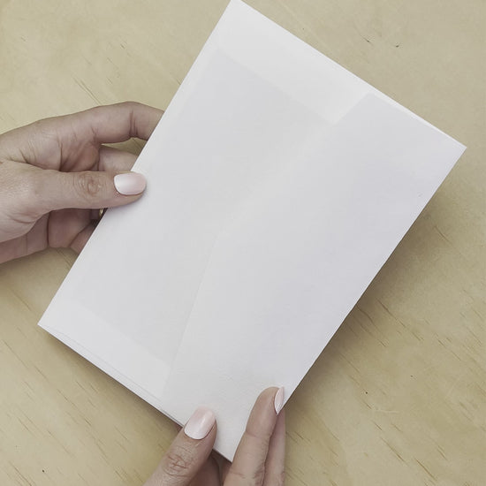 A movie reveal of the Aurora Rose wedding invitation with white envelope. A design by Communique Design.